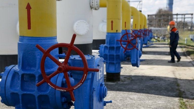 An employee passes near valves and pipes at a gas compressor station in the village of Boyarka, outside Kiev