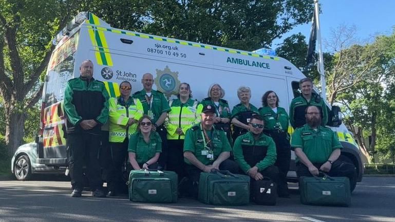 St John Ambulance volunteers in front of an ambulance