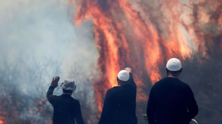Men watching large flames