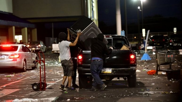 Las personas colocan mercancías de una ferretería en un camión durante la propagación en Filadelfia, Pensilvania, el 31 de mayo de 2020
