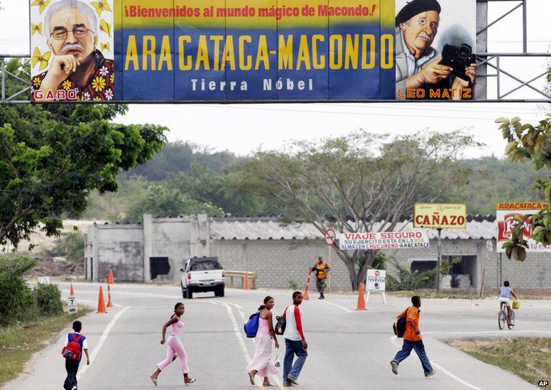People pass under a billboard reading Welcome to the magical world of Macondo, as they enter Aracataca, Colombia, 4 JAN 2006.