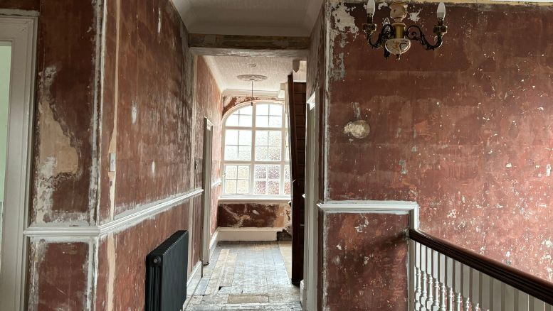 A view of the upstairs hall and landing in Claire Massey's home  where the plaster has been taken off the walls to remove the soot and smoke damage