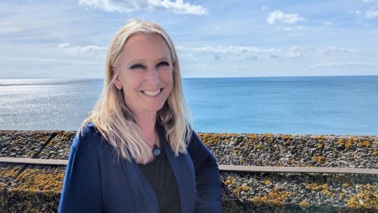 Dr Roz Savage by the seafront at the Liberal Democrat autumn conference in Brighton. She has loose, shoulder-length blonde hair, black eye make-up and a royal blue cardigan with a black t-shirt underneath and a round, blue necklace.