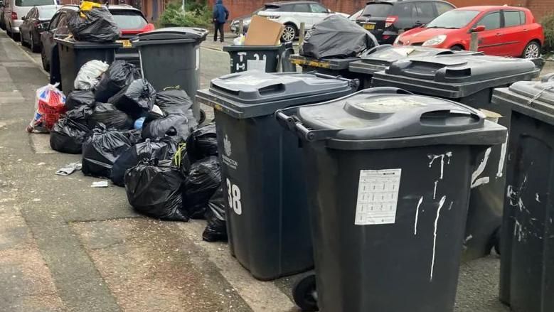 Rubbish next to bins in Warrington