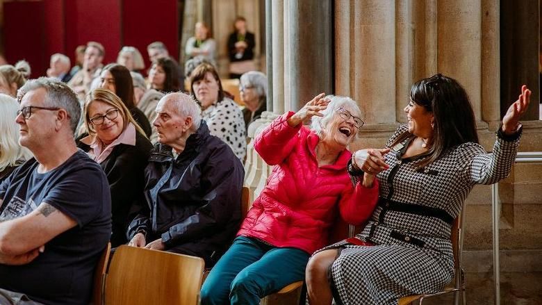Audience members smiling during the Bristol Beacon classical concert at Bristol Cathedral on Friday