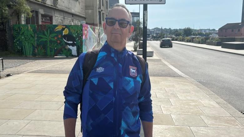 Peter Shelcot wearing a blue Ipswich Town tracksuit jacket. 