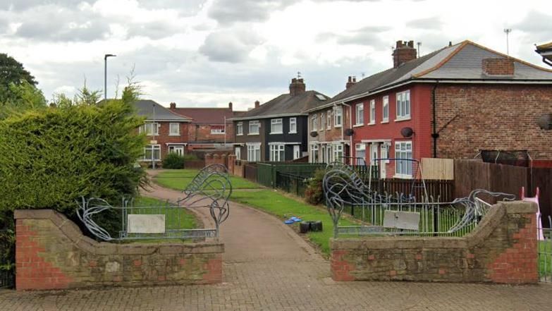 A path leading between a row of two-storey houses