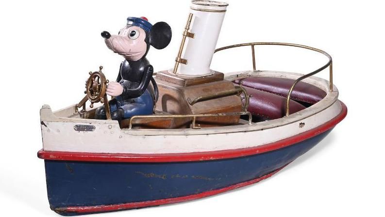 A small toy figure of a mouse steering a boat