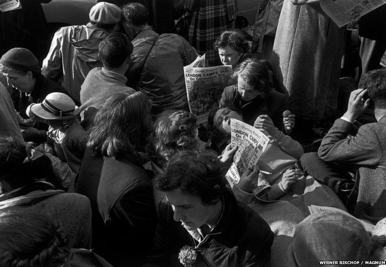 People reading newspapers ahead of the coronation