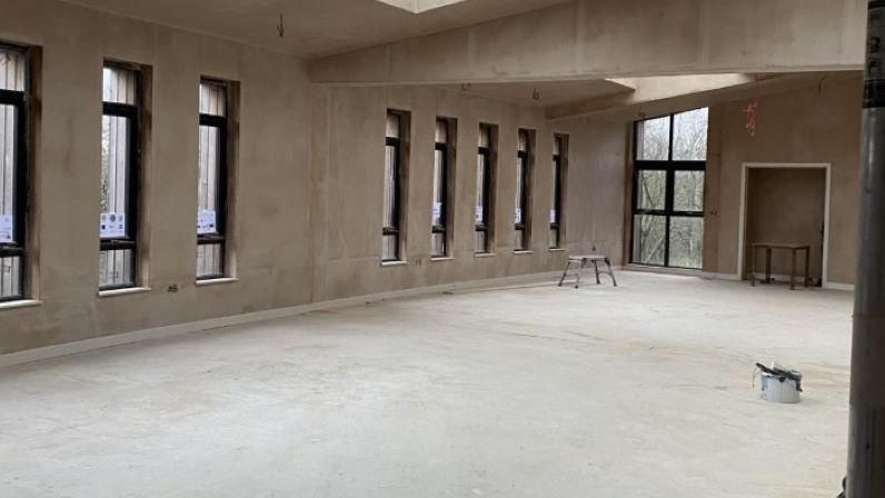 Empty walls and floors of the centre, with just a few stools and a lone paint tin