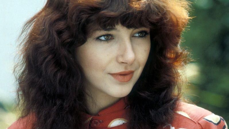 Musician Kate Bush wearing a red and white dress