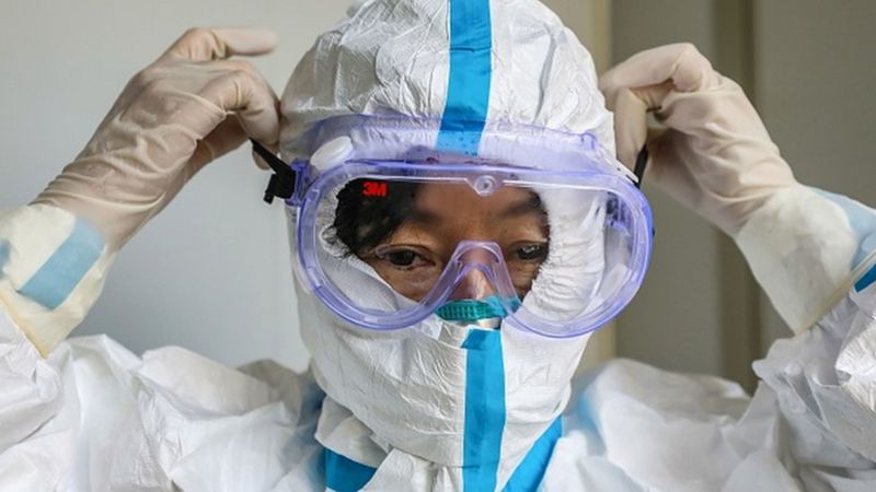 Membro da equipe de saúde colocando óculos de proteção