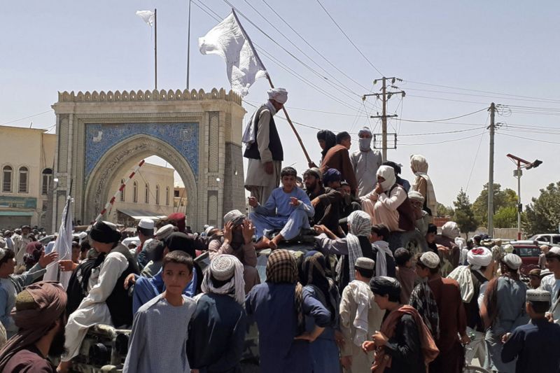 Combatientes talibanes parados en un vehículo junto a la carretera en Kandahar.