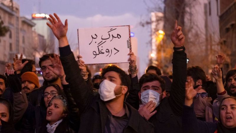 Manifestantes iranianos seguram cartaz que diz Morte ao Mentiroso