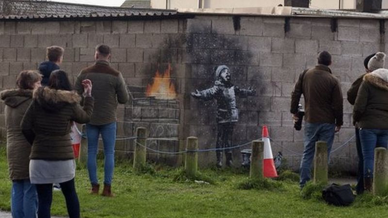 People gathering around the artwork