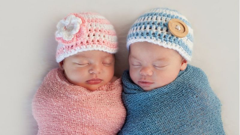 Baby girl and baby boy wrapped up next to each other