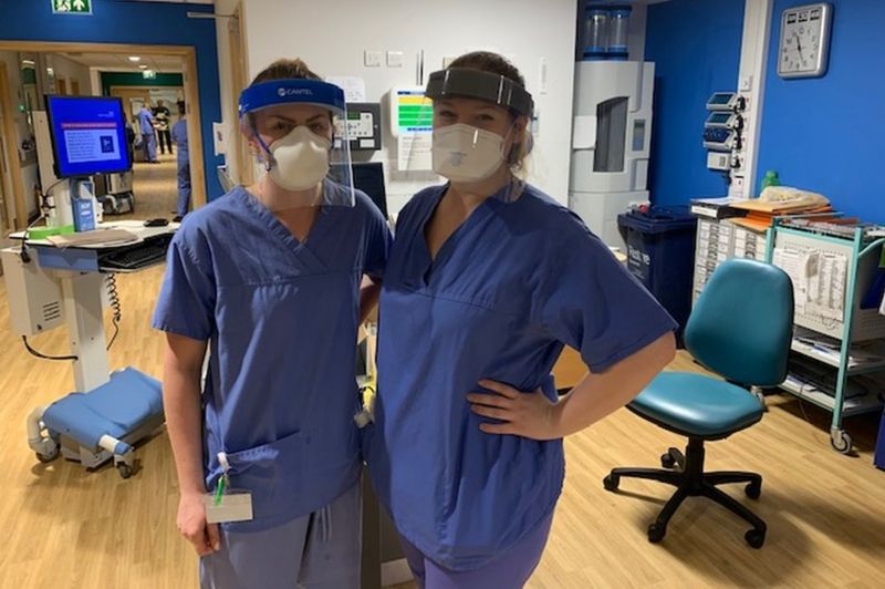 Two nurses wearing hospital scrubs