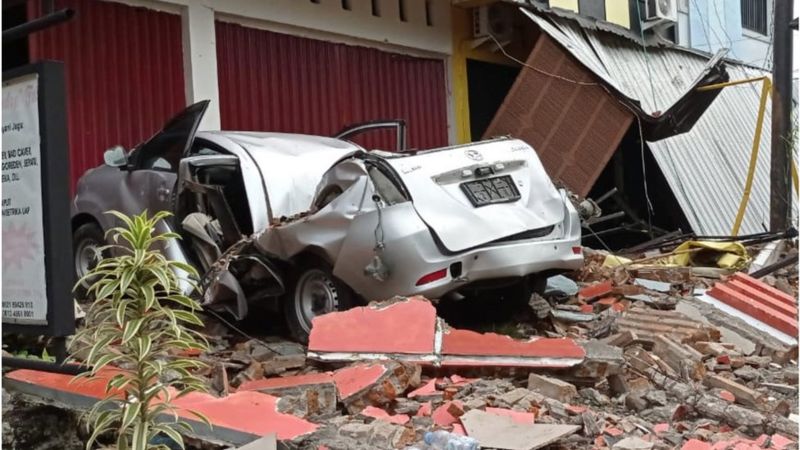 Sebuah mobil dan bangunan rusak akibat gempa bumi, di Mamuju, Sulawesi Barat, Jumat (15/1/2021).