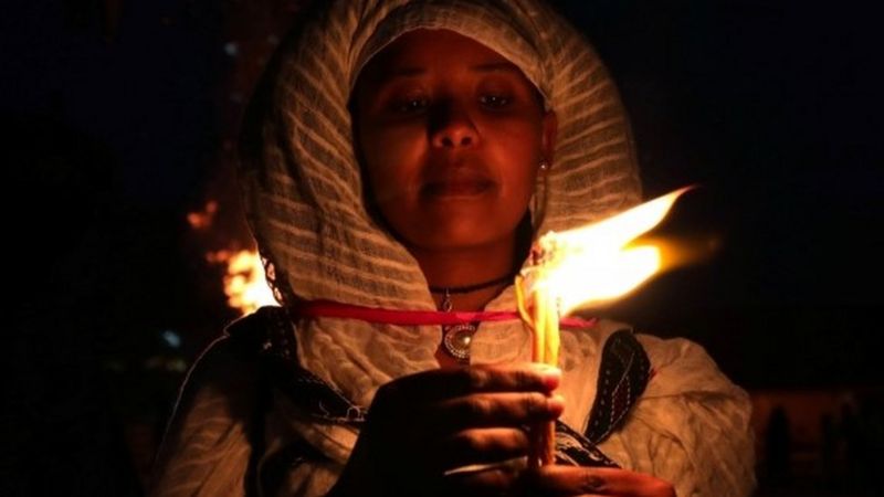 An Ethiopian Orthodox faithful holds a burning candle during the Meskel Festival to commemorate the discovery of the true cross on which Jesus Christ was crucified on, in Addis Ababa, Ethiopia, September 26, 2020