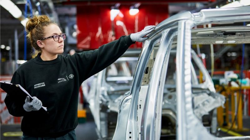 Car factory worker carrying out an inspection