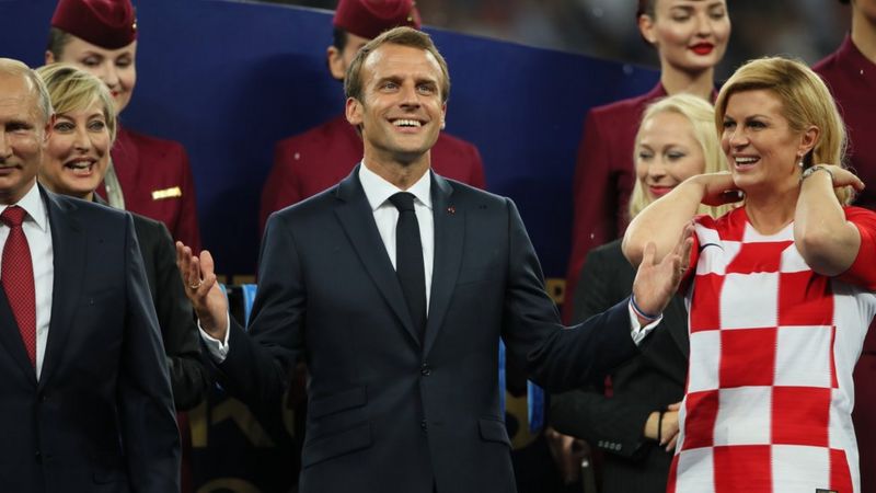 Tổng thống Nga Vladimir Putin đứng cạnh người tương nhiệm Pháp Emmanuel Macron và Croatia Kolinda Grabar-Kitarović đứng trong mưa chào đón các cầu thủ