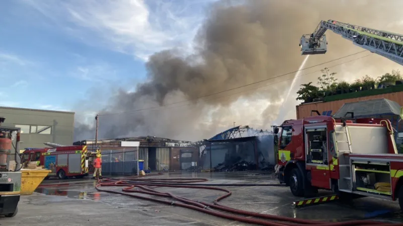 Los bomberos combaten un gran incendio en un almacén.