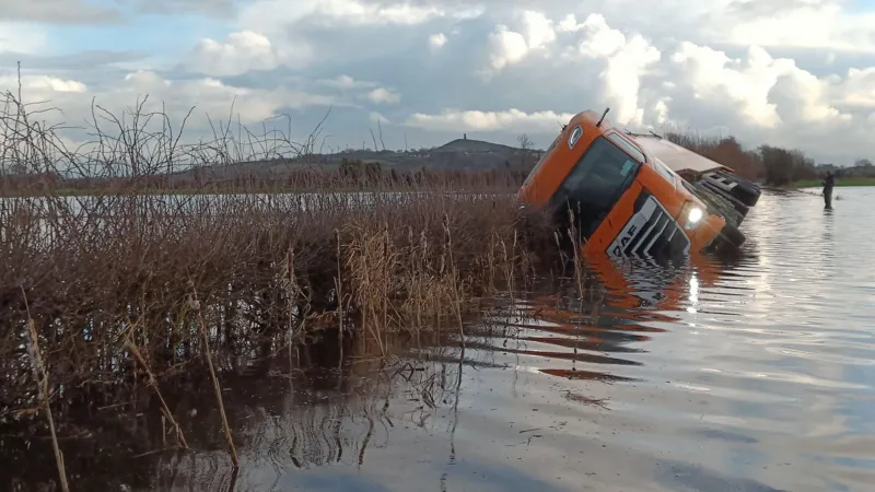 Un agricultor rescata a un conductor de camión de una carretera inundada