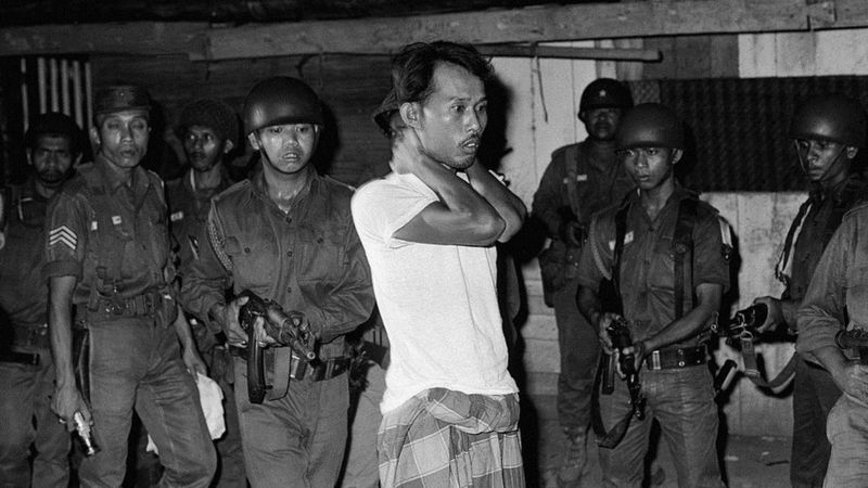 Sebagian para penyintas tragedi 1965 adalah orang-orang yang dulu aktif di sejumlah organisasi di bawah naungan PKI, seperti Lekra, Sarbuksi, atau Barisan Tani Indonesia. (Foto atas: Seseorang yang dituduh simpatisan PKI ditangkap oleh aparat militer Indonesia setelah 1 Oktober 1965).