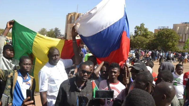 Демонстранты, вышедшие после военного переворота на улицы столицы Буркина-Фасо Уагадугу, держали в руках российские флаги