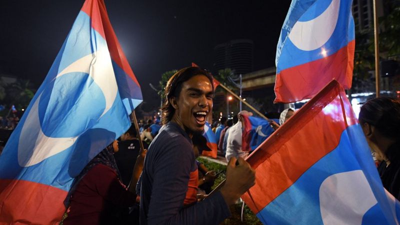 A supporter of Mr Mahathir celebrates in Kuala Lumpur on early 10 May 2018