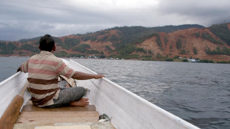 Seorang nelayan memandang lokasi pertambangan nikel di seberang Pulau Labengki selepas memancing ikan