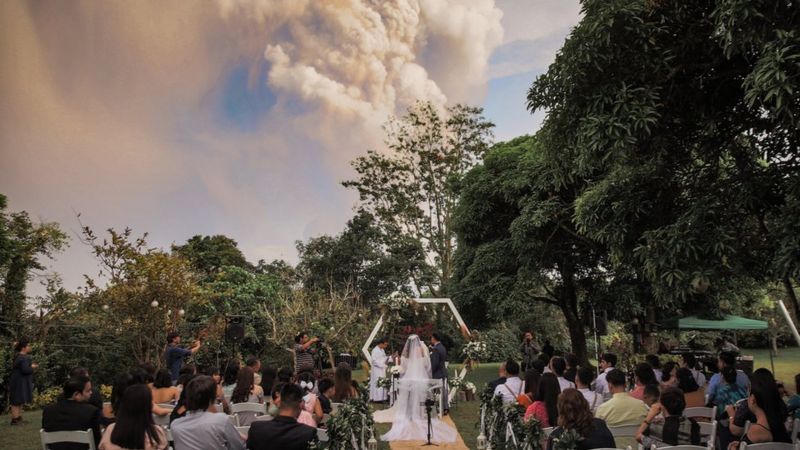 Foto de casamento com vulcão em erupção no fundo