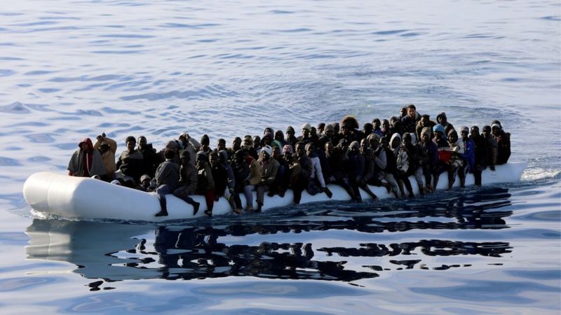 Migrants are seen in a rubber dinghy as they are rescued by Libyan coast guards off the coast of Libya, 15 January 2015