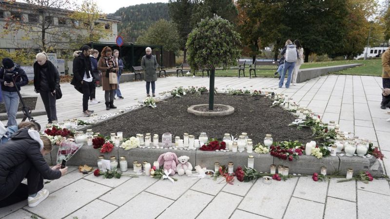 Местные жители ставят свечки в память о погибших в Конгсберге