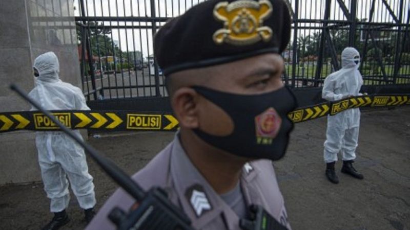 Polisi mengenakan masker dan pakaian hazmat saat mengamankan unjuk rasa penolakan buruh terhadap 'omnibus law' Rancangan Undang-Undangan (RUU) Cipta Kerja di depan kompleks Parlemen, Jakarta, Rabu (30/09/2020).