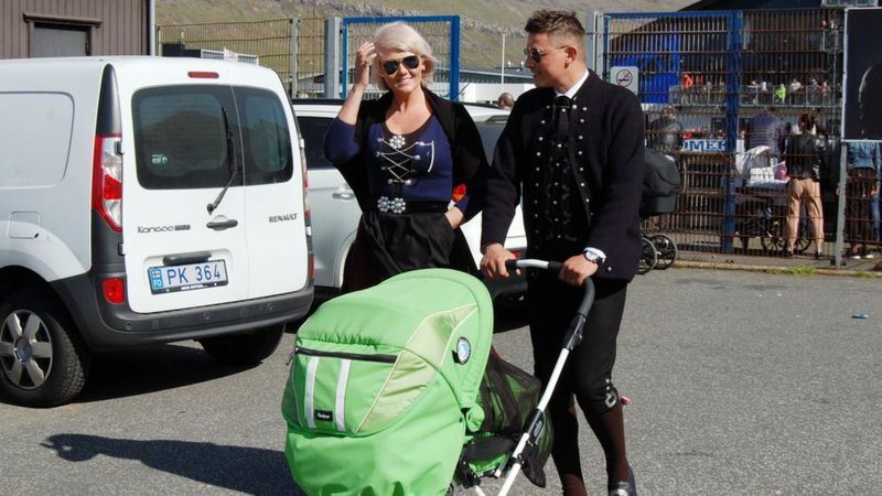 Một cặp đôi Đan Mạch mặc trang phục truyền thống đẩy xe em bé ở thị trấn Klaksvík.