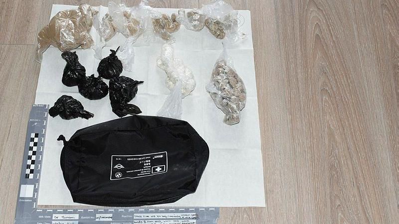 The seized black bag with packets of drugs laid out