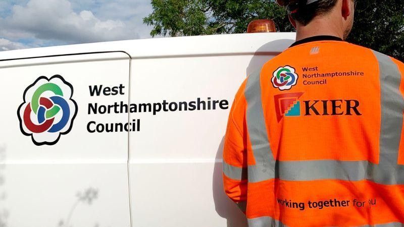 A white van with West Northamptonshire Council on it, with worker outside wearing Kier high-visibility jacket