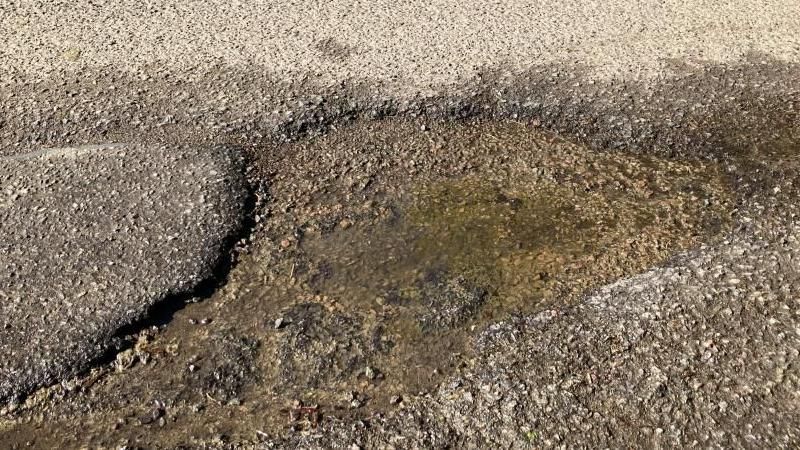 A large deep pothole in the road