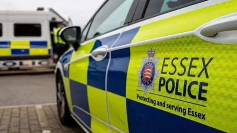 A close up of the side of a police car parked in a bay, with a label reading "Essex Police" on the rear left-side door. 