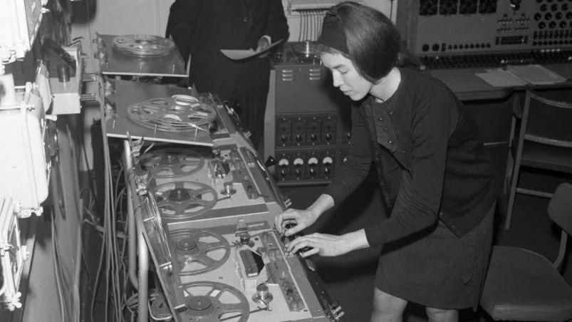 A black and white image of Delia Derbyshire editing a musical note
