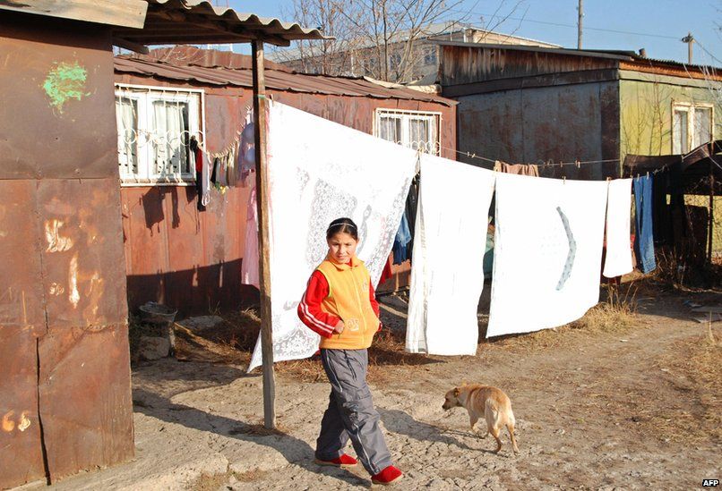A girl walks near small iron houses on the outskirts of Gyumri on December 7, 2008.