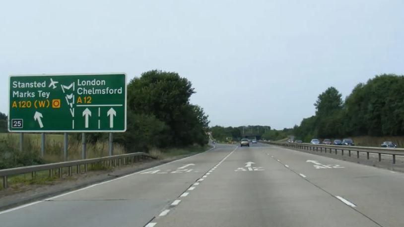 Three-lane dual carriageway with a road sign in the left corner