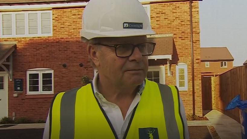 Ian Bird wearing a hard hat and high-vis jacket at a housing development in Burton-upon-Trent