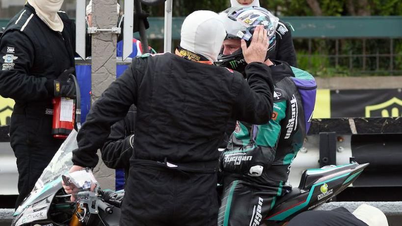 Michael Dunlop has a new visor fitted during his pit-stop