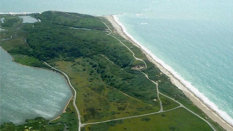 Aerial view of Hengistbury Head with the sea on one side and Christchurch harbour on the other