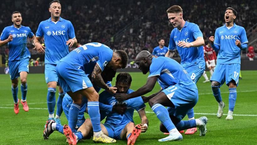 Napoli players run to join Kvicha Kvaratskhelia at the corner flag to celebrate his goal