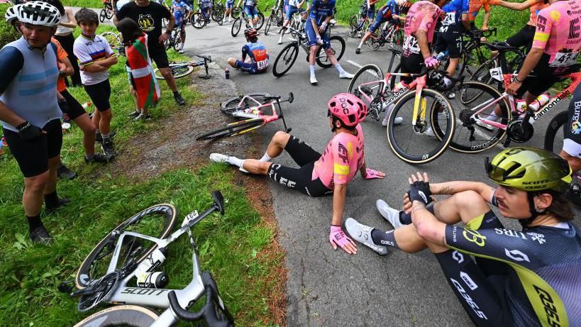 Cyclists sit on the ground following a crash