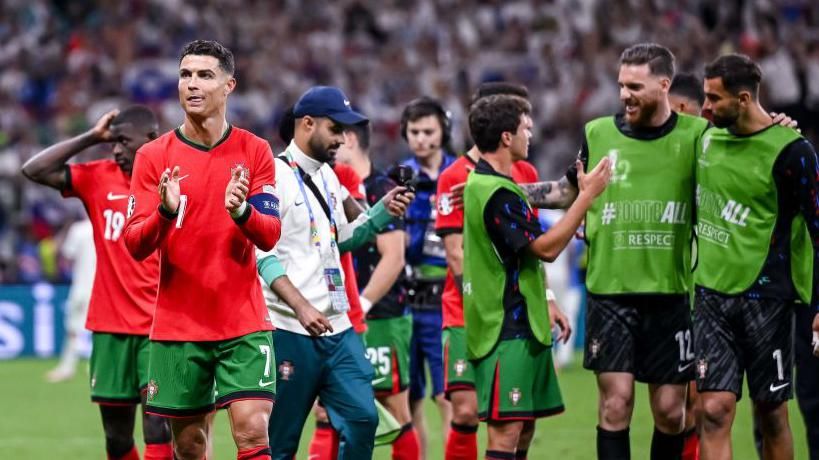 Portugal players celebrate beating Slovenia on penalties