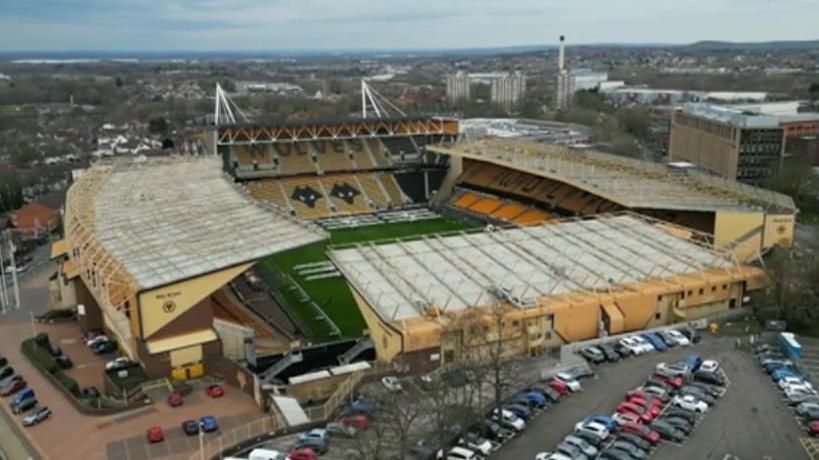 Aerial picture of Wolverhampton's Molineux stadium, showing the stands, cars parked in front and city buildings behind